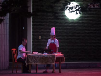 TOPSHOT - A photo taken on July 22, 2017 shows a man eating at a table outside a restaurant in Pyongyang. / AFP PHOTO / Ed JONES (Photo credit should read ED JONES/AFP via Getty Images)