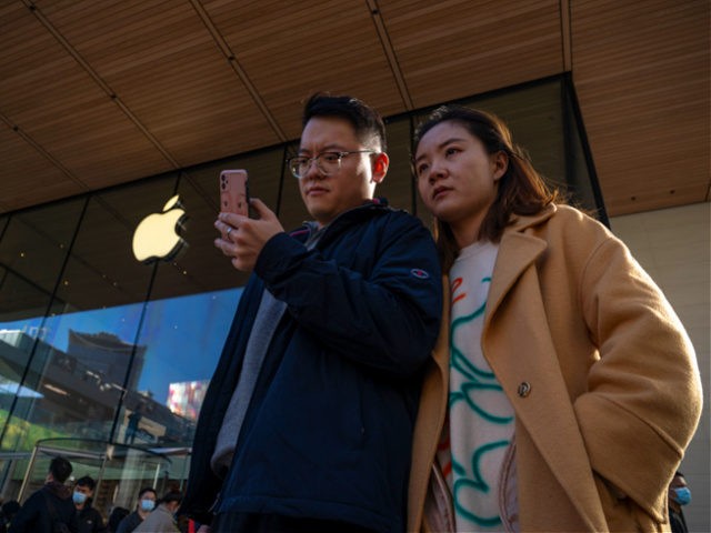 BEIJING, CHINA - OCTOBER 16: People watch a phone in front of an Apple store on October 16