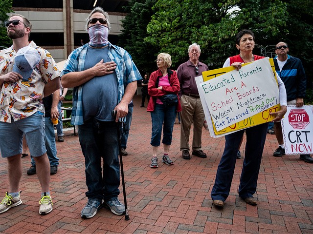 People hold up signs during a rally against "critical race theory" (CRT) being taught in schools at the Loudoun County Government center in Leesburg, Virginia on June 12, 2021. - "Are you ready to take back our schools?" Republican activist Patti Menders shouted at a rally opposing anti-racism teaching that critics like her say trains white children to see themselves as "oppressors." "Yes!", answered in unison the hundreds of demonstrators gathered this weekend near Washington to fight against "critical race theory," the latest battleground of America
