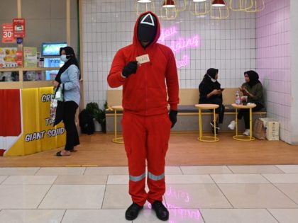 A man dressed in an outfit from the Netflix series 'Squid Game' stands to attract people to a restaurant in Jakarta on October 20, 2021. (Photo by ADEK BERRY / AFP) (Photo by ADEK BERRY/AFP via Getty Images)