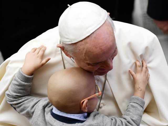 Pope Francis is hugged by a child during the general audience in Paul VI Hall at the Vatic