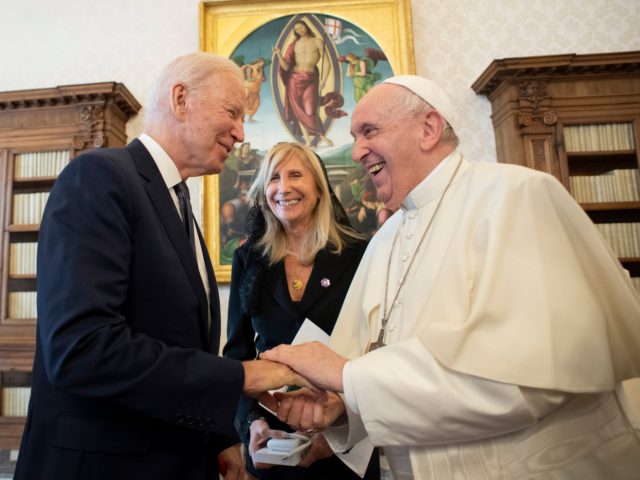 US President Joe Biden, left, shakes hands with Pope Francis as they meet at the Vatican,