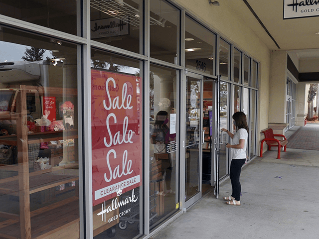 A sale sign is displayed near the entrance of a Hallmark store Tuesday, Jan. 12, 2021, in Orlando, Fla. Retail sales fell for a third straight month, as a surge in virus cases kept people away from stores and restaurants during the holiday shopping season. The report released Friday is yet another sign that the pandemic is slowing the U.S. economy. Last month, the country lost jobs for the first time since the spring.(AP Photo/John Raoux)