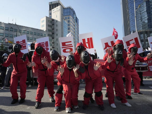 Members of the South Korean Confederation of Trade Unions wearing masks and costumes inspired by the Netflix original Korean series "Squid Game" perform during a rally demanding job security in Seoul, South Korea, October 20, 2021. (AP Photo/Ahn Young-joon)