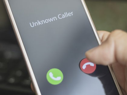 Unknown caller. A man holds a phone in his hand and thinks to end the call. Incoming from an unknown number. Incognito or anonymous