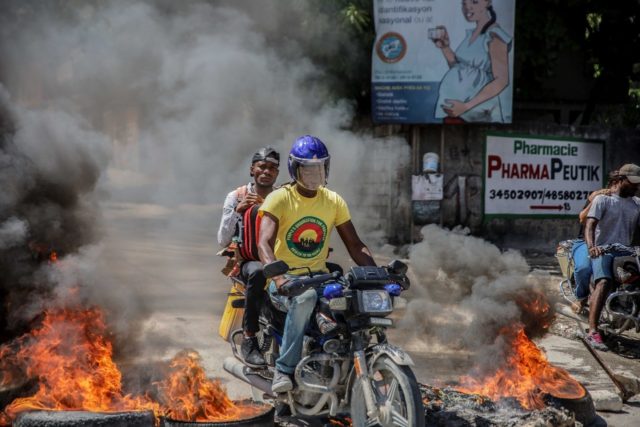 Blazing barricades burn after being set on fire by groups of motorcycle taxi drivers in Po