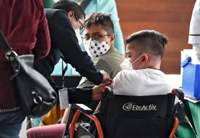 A minor in Mexico City is inoculated with the Pfizer-BioNtech vaccine against Covid-19 as