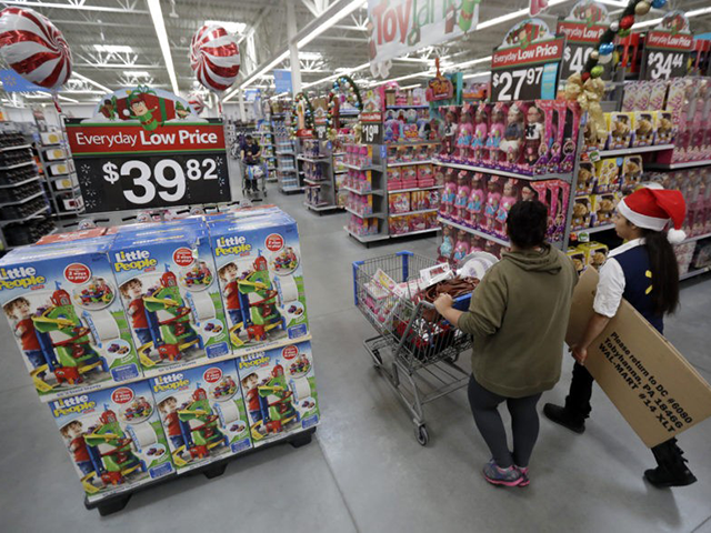In this Wednesday, Oct. 26, 2016, file photo, a shopper, left, walks with a store associate in the toy section at Walmart in Teterboro, N.J. Walmart hopes to tempt shoppers with online deals before Black Friday. It’s beginning some online deals Thursday and plans to offer most of its Black …