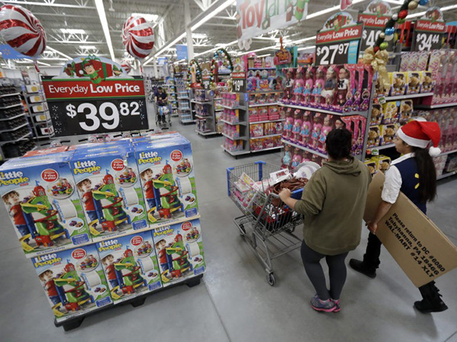 In this Wednesday, Oct. 26, 2016, file photo, a shopper, left, walks with a store associat