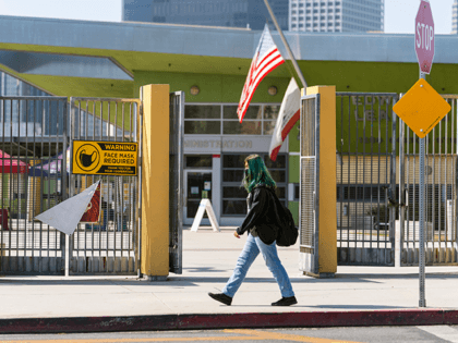 A student walks past the open doors of the Edward R. Roybal Learning Center in Los Angeles Thursday Sept. 9, 2021. The Los Angeles board of education is expected to vote Thursday, on whether to require all students 12 and older to be fully vaccinated against the coronavirus to participate …