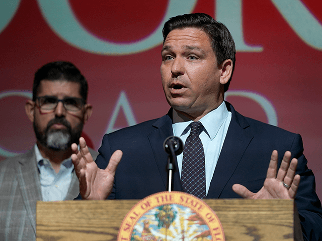 In this Tuesday, Sept. 14, 2021, file photo, Florida Gov. Ron DeSantis speaks at the Doral Academy Preparatory School in Doral, Fla. Florida filed suit against President Joe Biden's administration Tuesday, Sept. 28, 2021, claiming his immigration policy is illegal, and DeSantis signed an order barring state agencies from assisting …