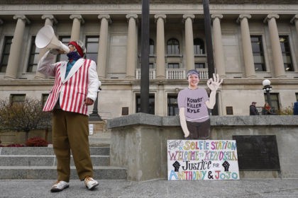 A protester stands outside the Kenosha County Courthouse, Tuesday, Nov. 16, 2021 in Kenosha, Wis., during the Kyle Rittenhouse murder trial. Rittenhouse is accused of killing two people and wounding a third during a protest over police brutality in Kenosha, last year. (AP Photo/Paul Sancya)