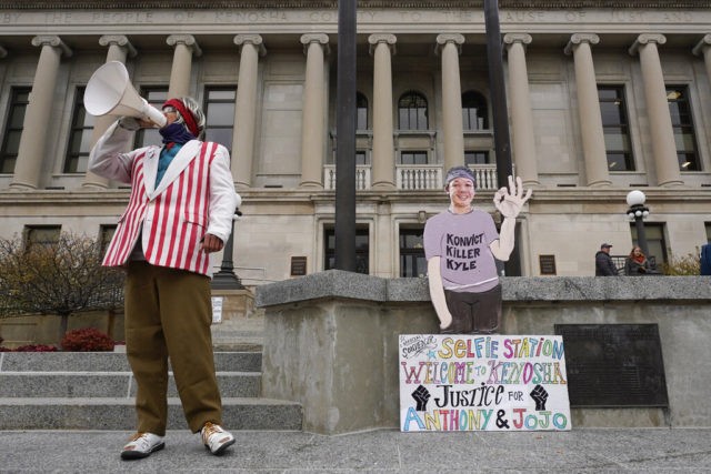 A protester stands outside the Kenosha County Courthouse, Tuesday, Nov. 16, 2021 in Kenosh