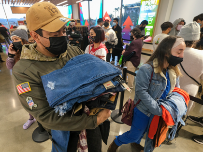 Black Friday shoppers wearing face masks shop at a store at the Citadel Outlets in Commerc