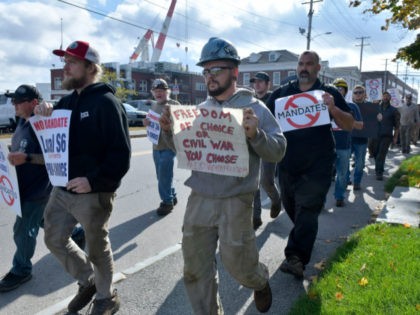 Justin Paetow, center, a tin shop worker at Bath Iron Works, takes part in a demonstration against COVID-19 vaccine mandate outside the shipyard on Friday, Oct. 22, 2021, in Bath, Maine. Some American workers are making the painful decision to quit their jobs and abandon cherished careers in defiance of …