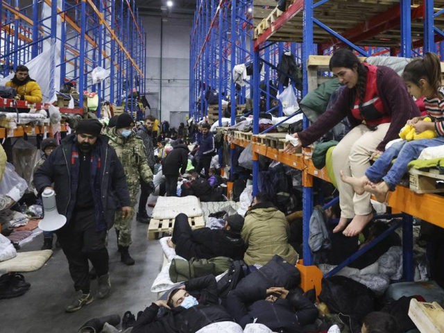 Migrants settle in a logistics center at the checkpoint "Kuznitsa" at the Belarus-Poland border near Grodno, Belarus, on Friday, Nov. 19, 2021. Polish authorities said Friday there are no more migrants camping along the Belarus side of the European Union's eastern border, but attempts at illegally crossing into the bloc's …