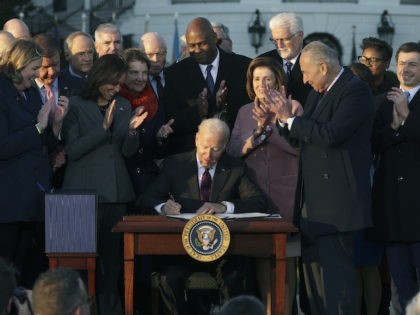President Joe Biden signs the Infrastructure Investment and Jobs Act as he is surrounded by lawmakers and members of his Cabinet during a ceremony on the South Lawn at the White House on November 15, 2021 in Washington, DC. (Alex Wong/Getty Images)