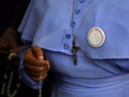 A Catholic faithful holding a rosary attends a march on the streets of Abuja during a pray