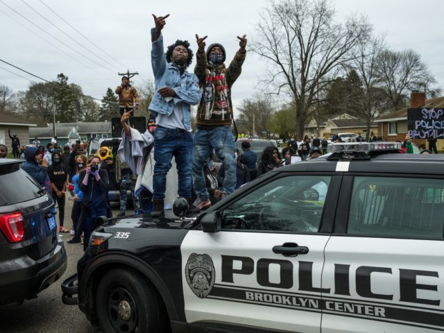 People stand on a police cruiser as protesters take to the streets after Brooklyn Center police shot and killed Daunte Wright during a traffic stop on April 11, 2021 in Brooklyn Center, Minnesota. A crowd gathered to confront police as they held a line while investigators searched the scene. (Photo by Stephen Maturen/Getty Images)