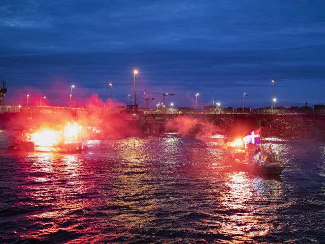 French fishermen light flares as they block the entrance to the port of Saint-Malo, western France, Friday, Nov. 26, 2021. French fishing crews are threatening to block French ports and traffic under the English Channel on Friday to disrupt the flow of goods to the U.K., in a dispute over …