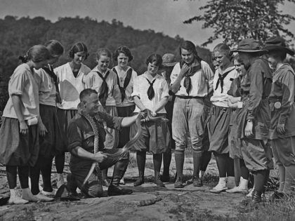 A group of Girl Guides being shown a snake while at camp circa 1920. (Photo by Paul Thomps