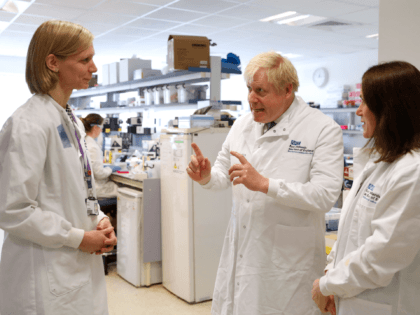 CAMBRIDGE, ENGLAND - OCTOBER 31: British Prime Minister Boris Johnson gestures as he speaks to Dr Anna Godfrey (L) and Dr Sarah Bowdin (R) at the East Midlands and East of England Genomic Laboratory Hub at Addenbrooke's Hospital on October 31, 2019 in Cambridge, England. (Photo by Alastair Grant - …