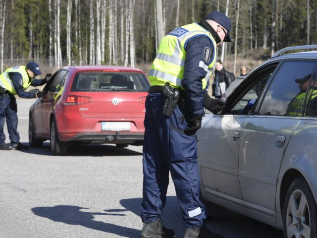 Policemen talk with road users at a check point in Mäntsälä, at the northern border of the Uusimaa (Nyland) region in Finland on March 28, 2020. - The Finnish Government decided to restrict traffic between the Uusimaa and other regions to prevent coronavirus infections and to slow the spread of …