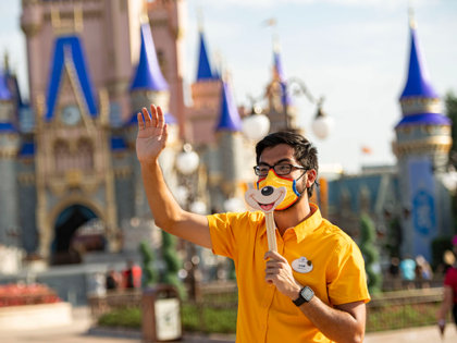 In this handout photo provided by Walt Disney World Resort, a Disney cast member welcomes guests to Magic Kingdom Park at Walt Disney World Resort on July 11, 2020 in Lake Buena Vista, Florida. July 11, 2020 is the first day of the phased reopening. (Photo by Matt Stroshane/Walt Disney …