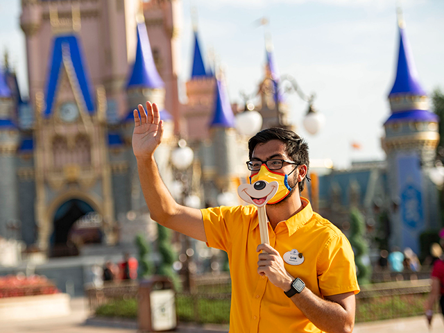 In this handout photo provided by Walt Disney World Resort, a Disney cast member welcomes guests to Magic Kingdom Park at Walt Disney World Resort on July 11, 2020 in Lake Buena Vista, Florida. July 11, 2020 is the first day of the phased reopening. (Photo by Matt Stroshane/Walt Disney World Resort via Getty Images)