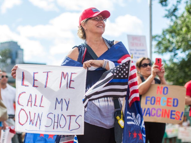 BOSTON, MA - AUGUST 30: Anti-vaccine activists hold signs in front of the Massachusetts State House during a protest against Governor Charlie Baker's mandate that all Massachusetts school students enrolled in child care, pre-school, K-12, and post-secondary institutions must receive the flu vaccine this year on August 30, 2020 in …