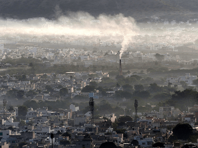 Smoke billows from a factory chimney during smoggy morning in Ajmer on November 2, 2020. (