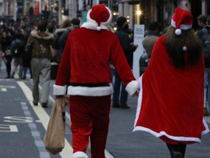 LONDON, ENGLAND - DECEMBER 12: People in Santa costumes walk amongst Christmas shoppers Regent Street on December 12, 2020 in London, England. (Photo by Hollie Adams/Getty Images)