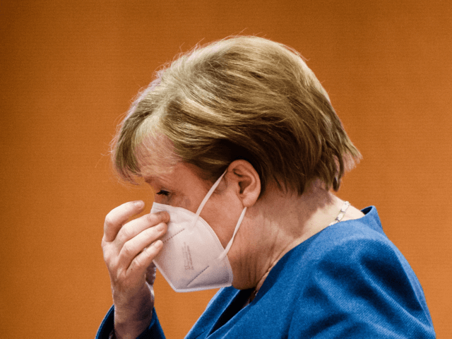 BERLIN, GERMANY - JANUARY 06: German Chancellor Angela Merkel touches her face mask as she