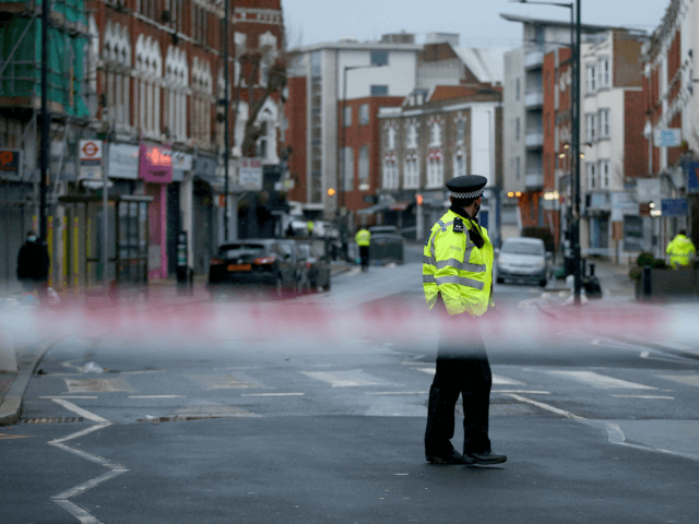 LONDON, ENGLAND - FEBRUARY 07: Metropolitan Police officers standing behind a police cordon at the scene of a stabbing at Willesden Lane on February 7, 2021 in London, England. Police were called to Willesden Lane on Saturday evening, where they found two males with stab wounds. One was pronounced dead …