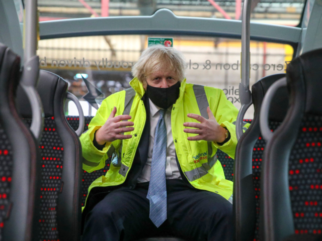 Britain's Prime Minister Boris Johnson talks to bus drivers aboard an electric bus during a visit to the National Express depot in Coventry, central England, on March 15, 2021 to unveil new policies aiming to transform the bus sector. - Britain's prime minister vowed on March 14 to take action …