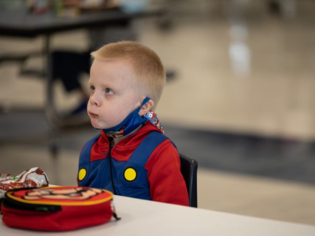 LOUISVILLE, KY - MARCH 17: A child with his mask lowered eats lunch at socially distanced tables in the cafeteria of Medora Elementary School on March 17, 2021 in Louisville, Kentucky. Today marks the reopening of Jefferson County Public Schools for in-person learning with new COVID-19 procedures in place. (Photo …