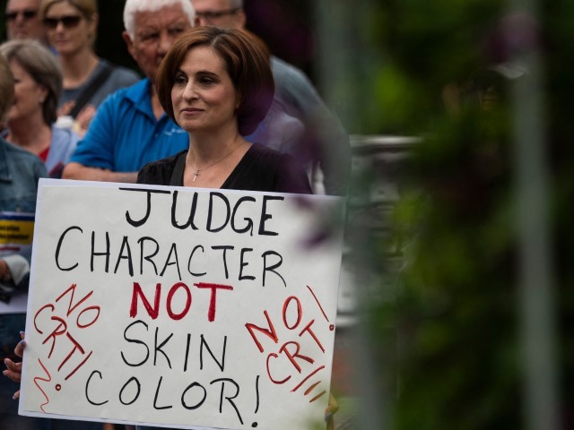 A woman holds up a sign during a rally against "critical race theory" (CRT) being taught in schools at the Loudoun County Government center in Leesburg, Virginia on June 12, 2021.