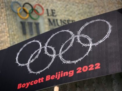 This photograph taken on June 23, 2021 shows a placard representing barber wire shaping and Olympics Rings are seen next to a sign of the Olympics Museum during a protest organised by Tibetan and Uyghur activists against Beijing 2022 Winter Olympics, in Lausanne as some 200 participants took part to …