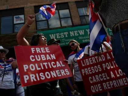People hold signs demanding the release of Cuban political prisoners during a protest showing support for Cubans demonstrating against their government, in Union City, New Jersey, on July 18, 2021. - Cuba's President Miguel Diaz-Canel on July 17 denounced what he said was a false narrative over unrest on the …
