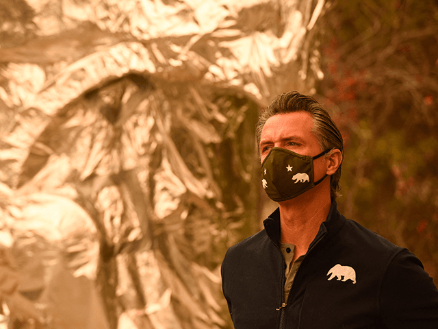 California Governor Gavin Newsom wears a face mask before a ceremony for a new climate bill at the Sequoia National Park near Three Rivers, California on September 23, 2021. - A $15 billion climate bill was signed with funding that will invest in wildfire and forest resilience, support drought response, …