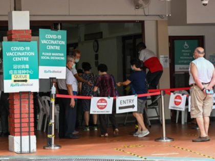 People enter a Covid-19 coronavirus vaccination centre set up at a community centre in Singapore on October 7, 2021. (Photo by Roslan Rahman / AFP) (Photo by ROSLAN RAHMAN/AFP via Getty Images)