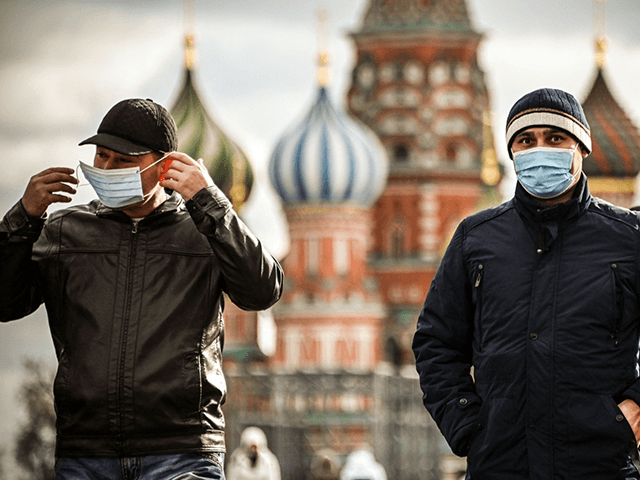 TOPSHOT - Tourists wearing face masks walk along Red Square in central Moscow on October 2