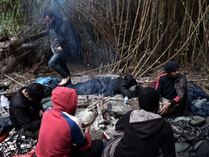 Migrants try to warm themselves by a fire near Idomeni at the border between Greece and North Macedonia on October 18, 2021. - Since the conservative government took office in 2019, Greece has steadily tightened asylum policies, rejecting thousands of applications and expelling hundreds of people from camps. Camped out …