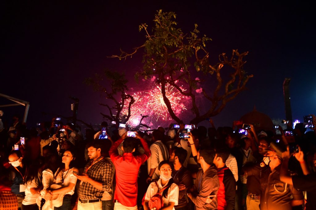 People watch fireworks along the banks of the river Sarayu during Deepotsav celebrations on the eve of the Hindu festival of Diwali in Ayodhya on November 3, 2021. (Photo by SANJAY KANOJIA / AFP) (Photo by SANJAY KANOJIA/AFP via Getty Images)