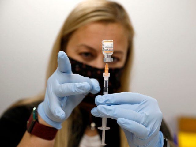Nurse practitioner Sarah Rauner fills a syringe with the Pfizer Covid-19 vaccine to be administered to children from 5-11 years old at the Beaumont Health offices in Southfield, Michigan on November 5, 2021. (Photo by JEFF KOWALSKY / AFP) (Photo by JEFF KOWALSKY/AFP via Getty Images)
