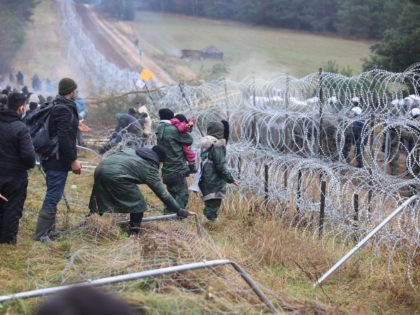 A picture taken on November 8, 2021 shows migrants at the Belarusian-Polish border in the Grodno region. - Poland on November 8 said hundreds of migrants in Belarus were descending on its border aiming to force their way into the EU member in what NATO slammed as a deliberate tactic …