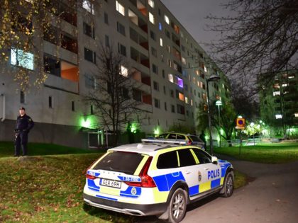 A police vehicle is parked outside an apartment block in north-western Stockholm after two