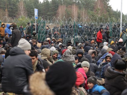 Migrants gather on the Belarusian-Polish border near the Polish border crossing in Kuznica on November 15, 2021. - Thousands of migrants -- most of them from the Middle East -- have crossed or attempted to cross the EU and NATO border since the summer. Western countries have accused the Belarusian …