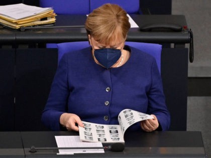 German Chancellor Angela Merkel consults the catalogue of the members of parliament during