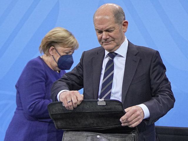 German Chancellor Angela Merkel (L) and German Finance Minister and candidate for Chancellor Olaf Scholz leave after addressing a press conference following a video meeting with the heads of government of Germany's federal states at the Chancellery in Berlin on November 18, 2021. - The Chancellor met with the regional …